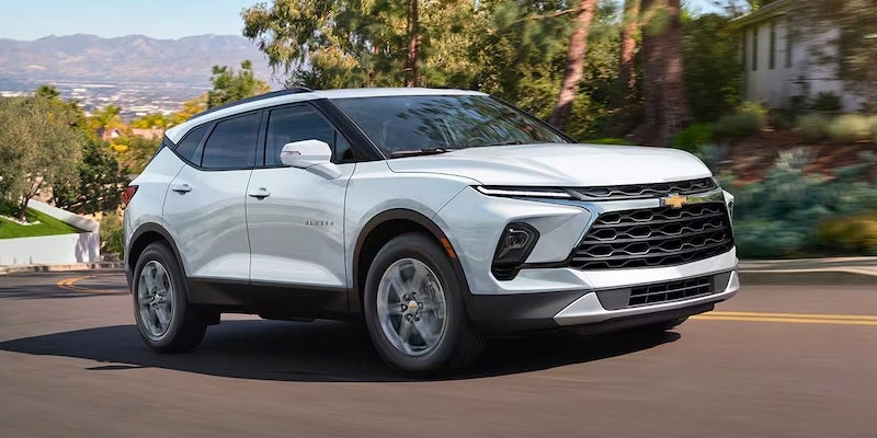 All-New 2024 Iridescent Pearl Tricoat Chevy Blazer cruising through a neighborhood's rolling hills. - McGregor , TX Dealer  