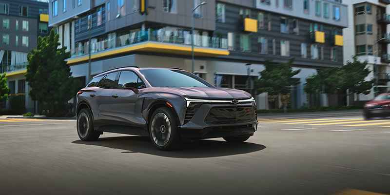 An all-new silver 2025 Chevy Blazer EV cruising through downtown streets. - Jim Turner Chevrolet McGregor, TX